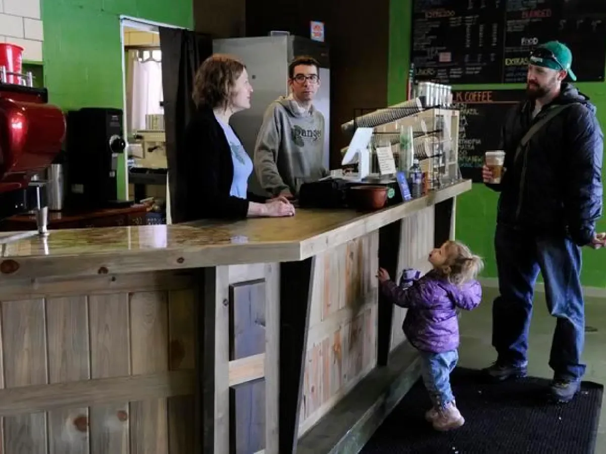 coffee shop counter with staff serving customer and young child in purple jacket., pangea coffee roasters, golden
