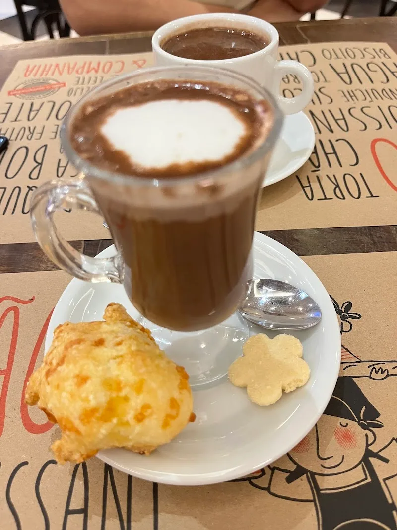 two hot chocolates with pastries on a decorative café table., pão & companhia, rio de janeiro