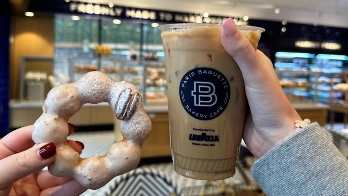 hand holding powdered pastry and iced coffee beverage at paris baguette bakery cafe., paris baguette, houston