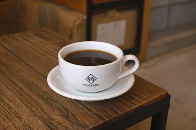 white coffee cup with saucer on wooden table in café setting., passage coffee, tokyo