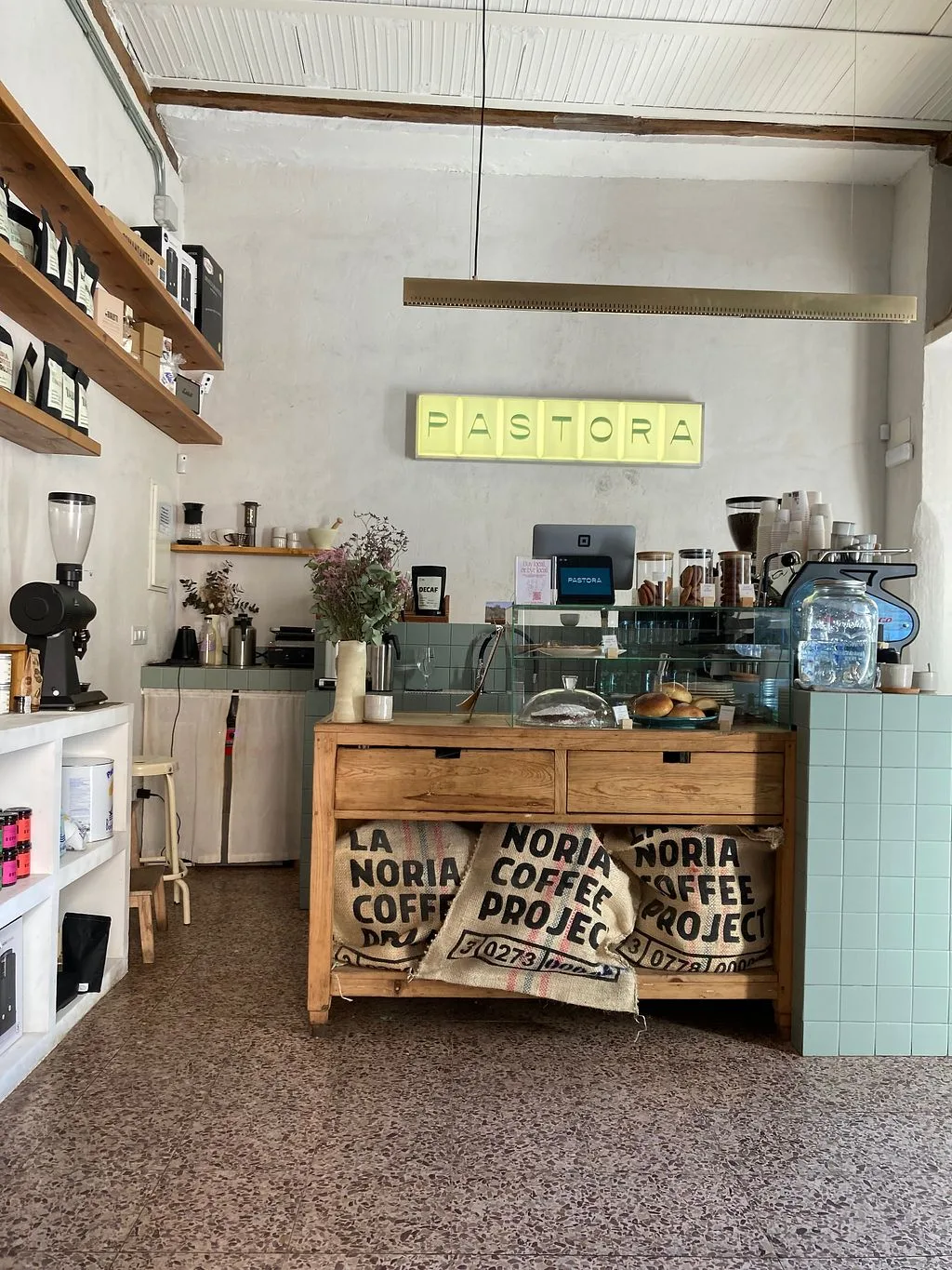 modern coffee shop interior with yellow neon "pastora" sign and wooden counter., pastora – café & bottle shop, madrid