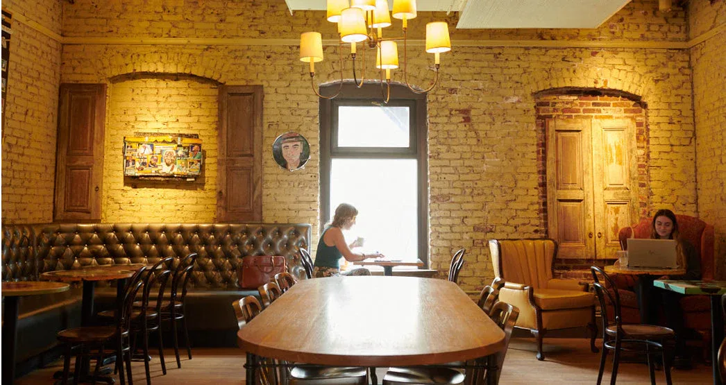 brick restaurant interior with wooden tables, leather seating, and warm lighting., pavement coffee, boston