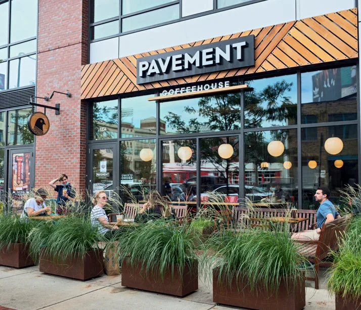 pavement coffeehouse storefront with outdoor seating and decorative potted grasses., pavement coffee, boston