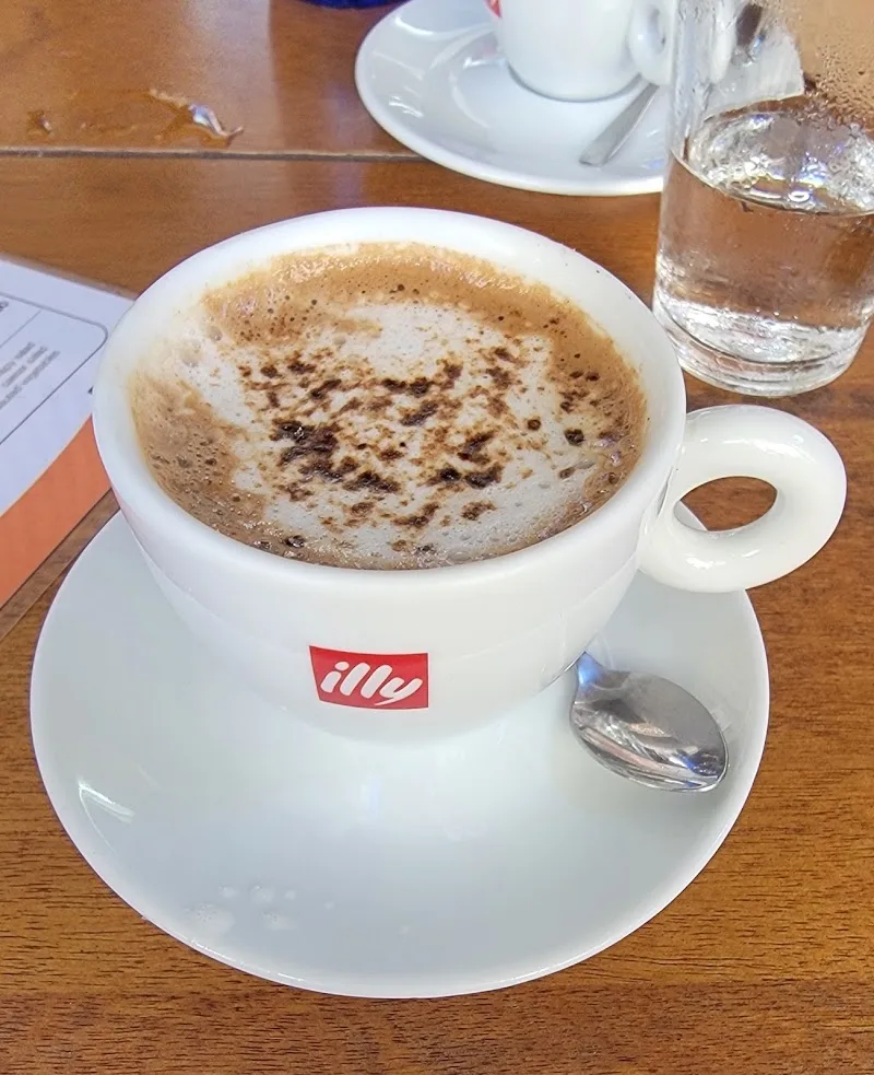 cappuccino with cocoa powder in illy branded white cup and saucer., pendê café, rio de janeiro