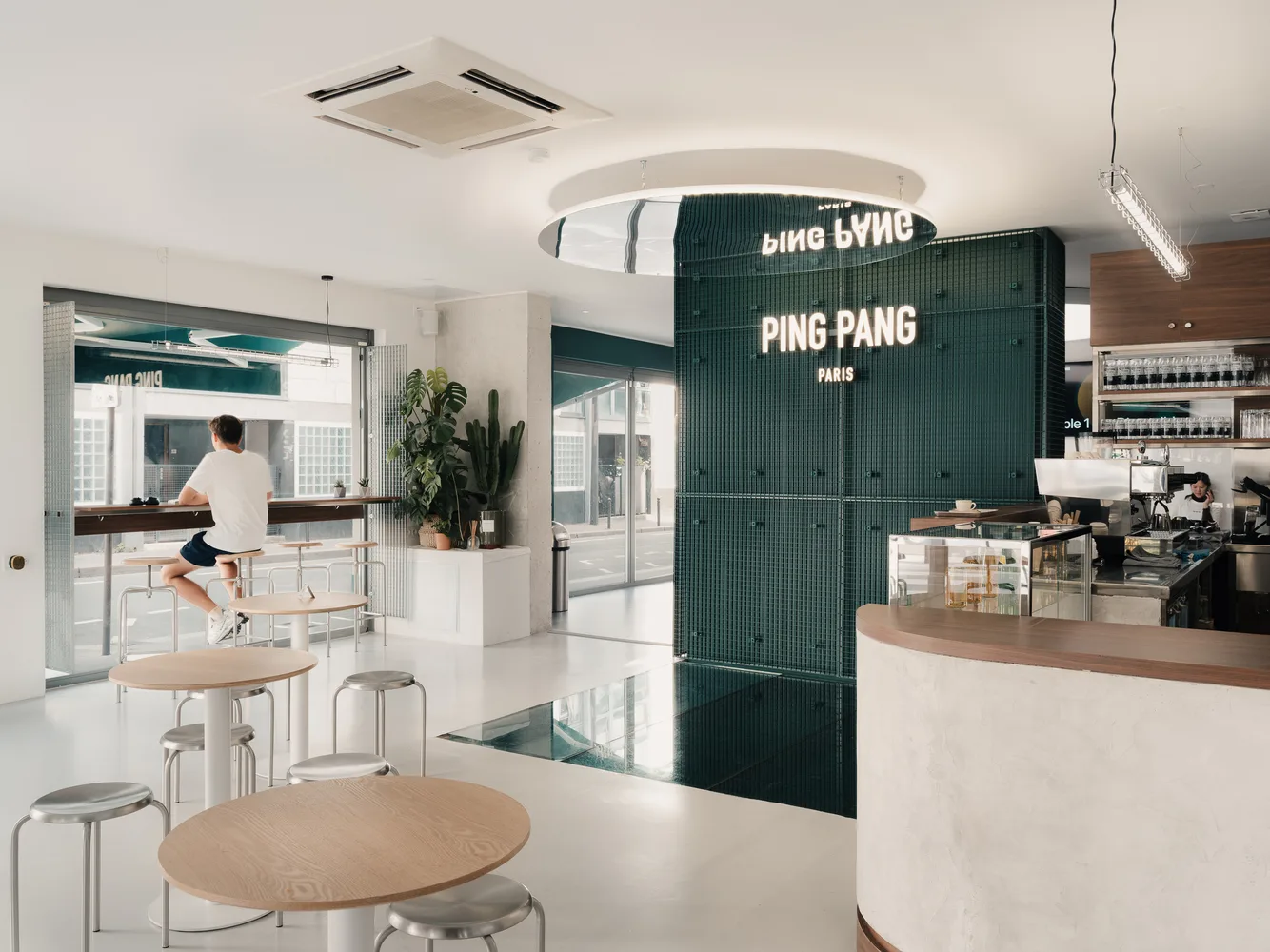 modern minimalist café interior with green structural element and wooden tables., ping pang paris, paris