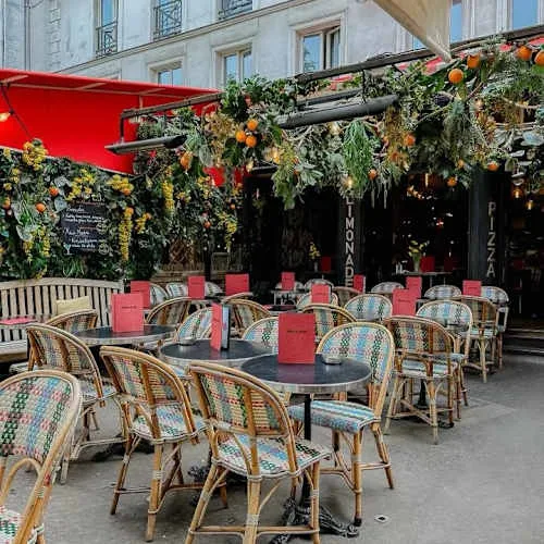 outdoor café with wicker chairs, round tables, and festive holiday garland decoration., pinocchio, paris