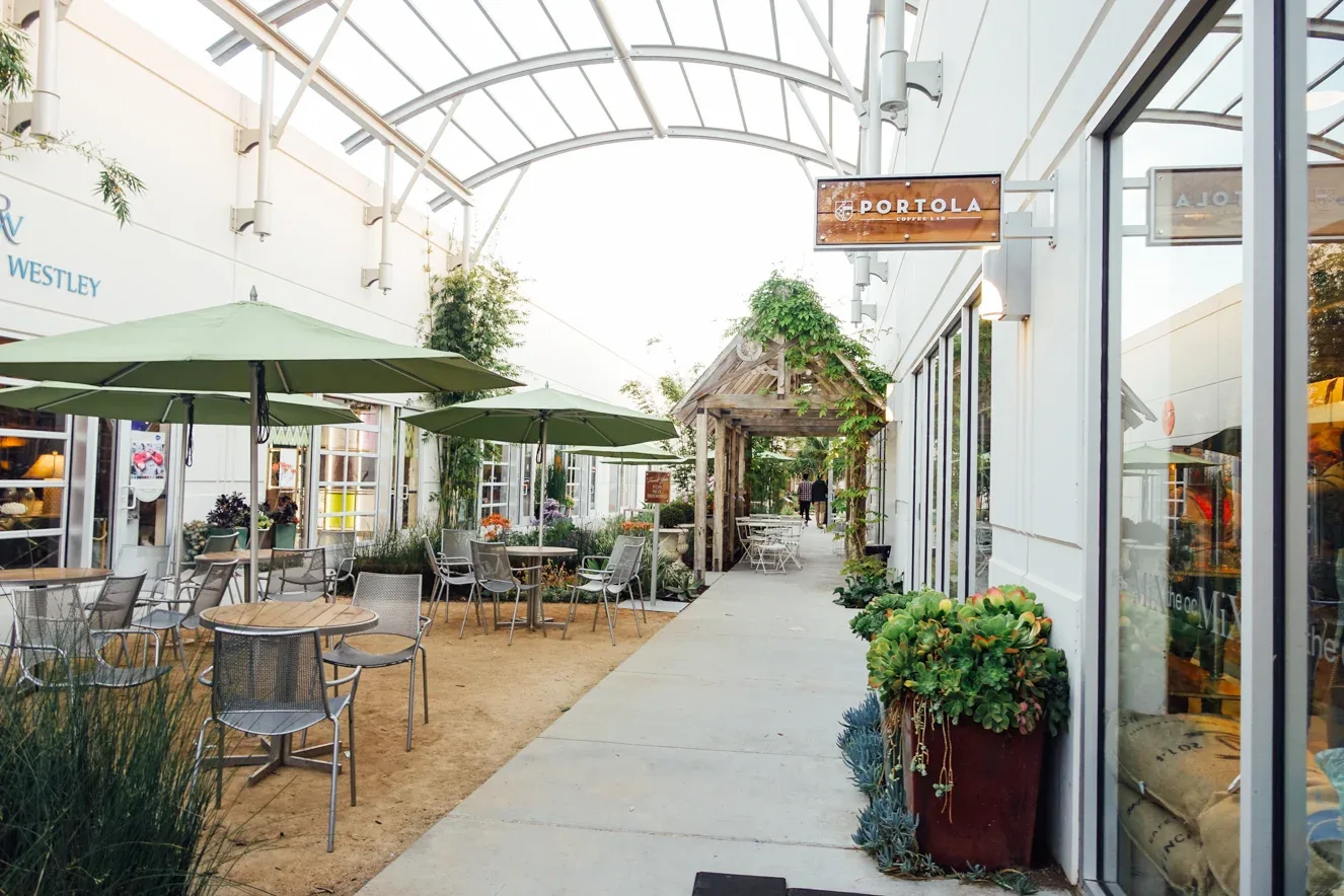 covered outdoor shopping arcade with restaurants, seating areas, and green umbrellas., portola coffee lab, costa mesa