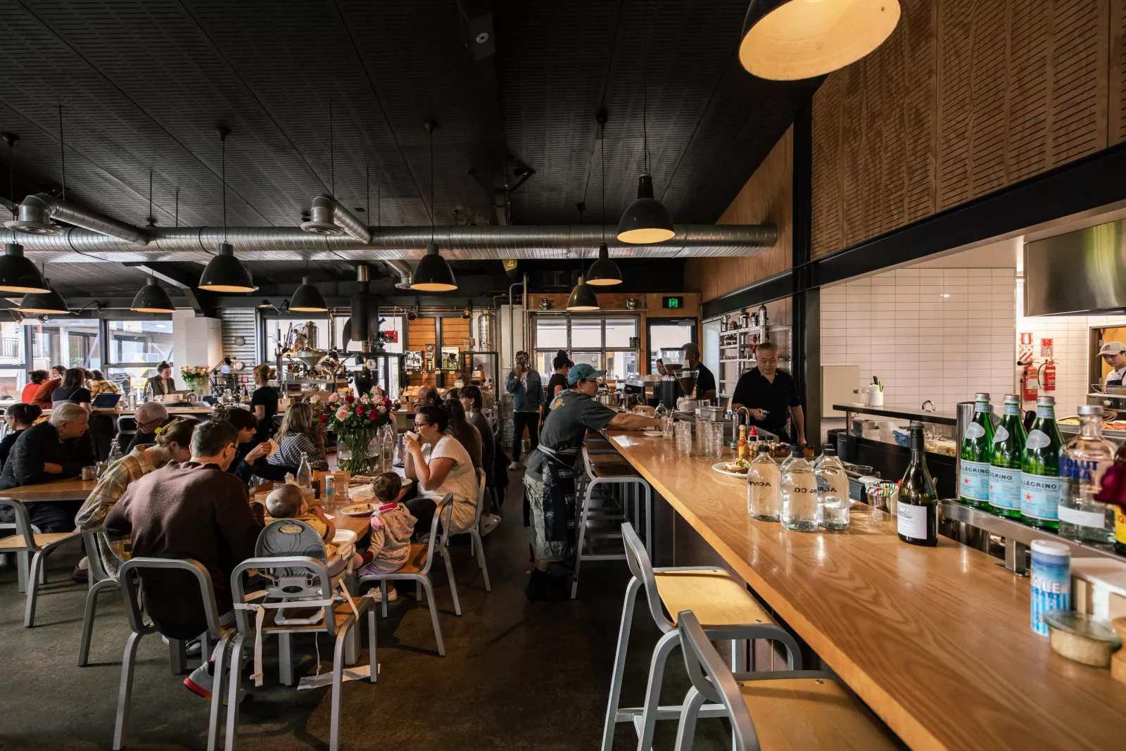 modern restaurant interior with diners, wooden bar counter, pendant lights., prefab-acme, wellington