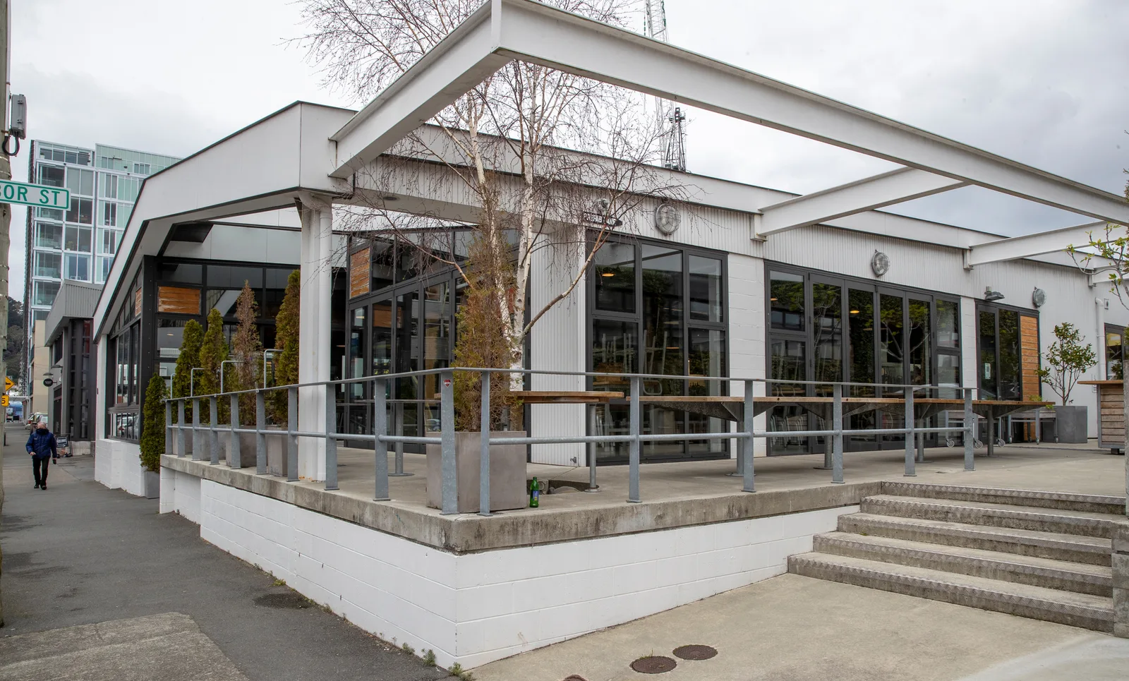 modern white building with steel railings and large windows overlooking plaza., prefab-acme, wellington