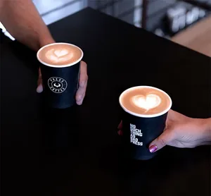 two hands holding dark cups with latte art on black table., press coffee - mccormick, phoenix