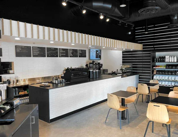 modern coffee shop interior with white counter, black accents, and wooden seating., press coffee - mccormick, phoenix