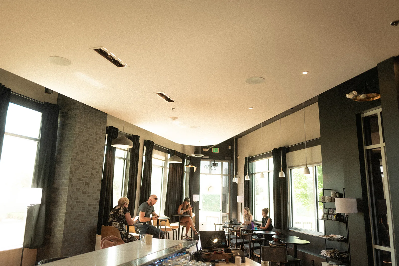 modern cafe interior with seated patrons, large windows, and industrial design elements., procession coffee, denver