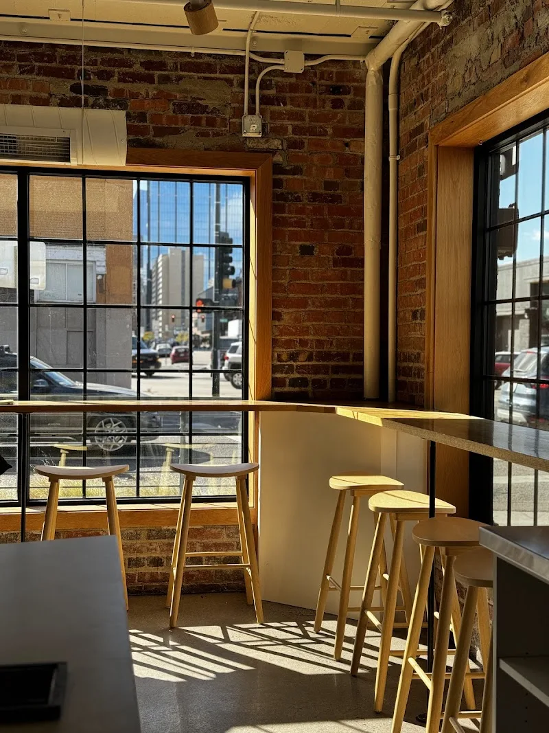 modern cafe interior with bar seating overlooking urban street below., procession coffee, denver