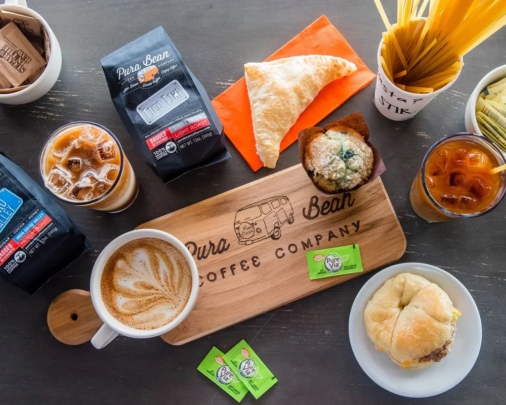 pura bean coffee company display with pastries, beverages, and branded serving board., pura bean coffee company, jacksonville