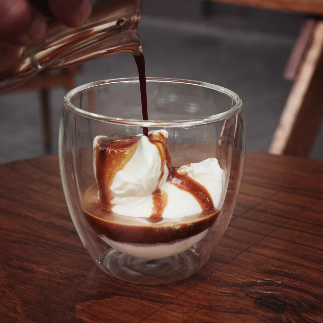 hot espresso being poured into glass with whipped cream and caramel drizzle., pura - café de especialidad, buenos aires
