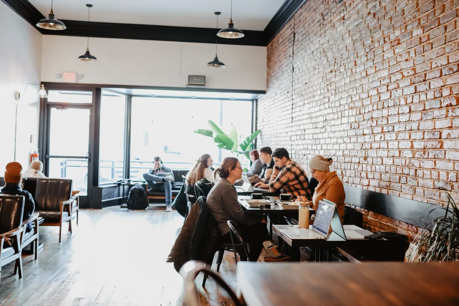 modern café interior with exposed brick, pendant lights, and patrons working on laptops., purebred coffee co., dayton