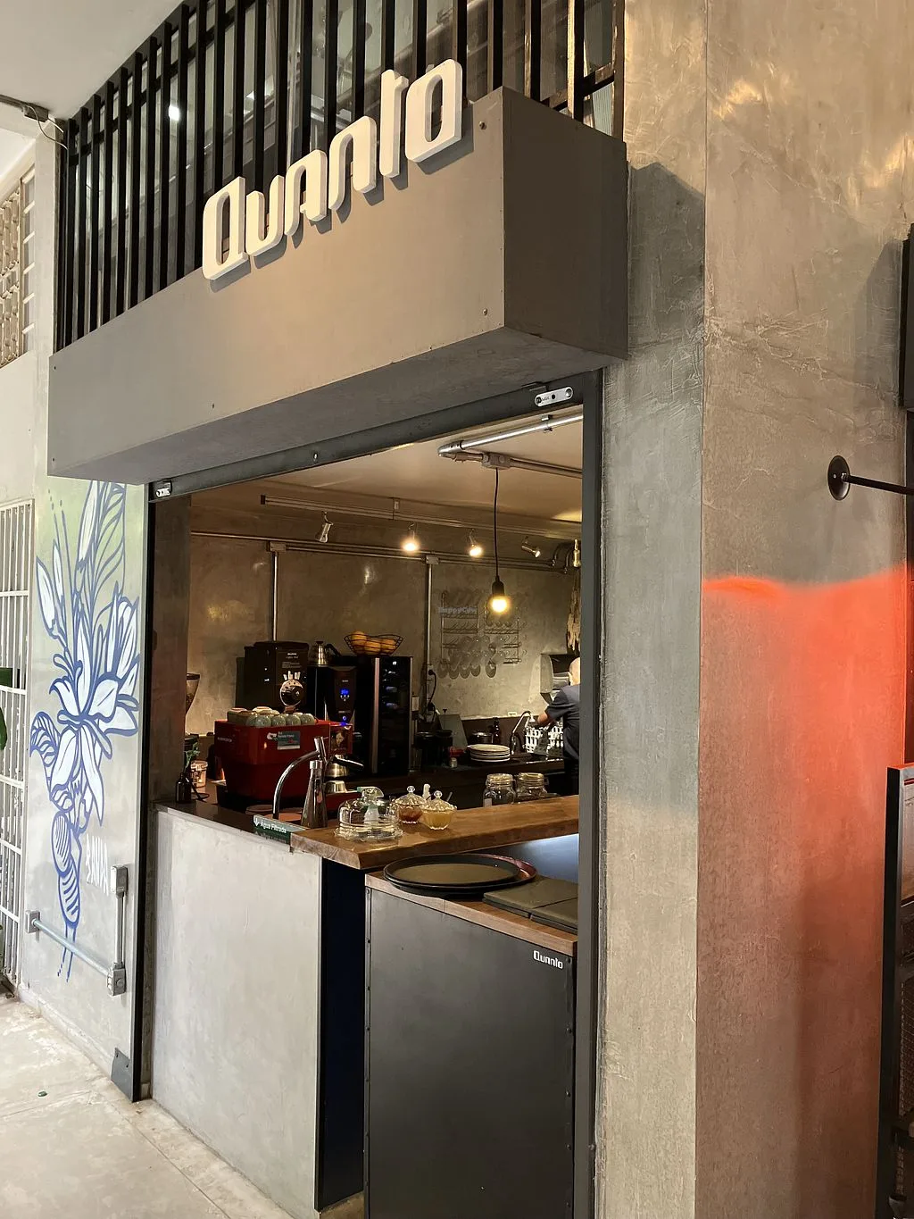 modern minimalist coffee shop storefront with illuminated signage and espresso equipment visible., quanto café, brasília