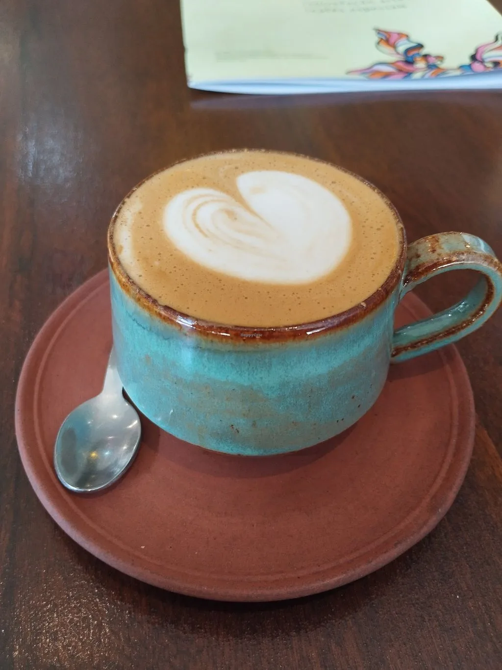 cappuccino with latte art in turquoise cup on terracotta saucer., quanto café, brasília