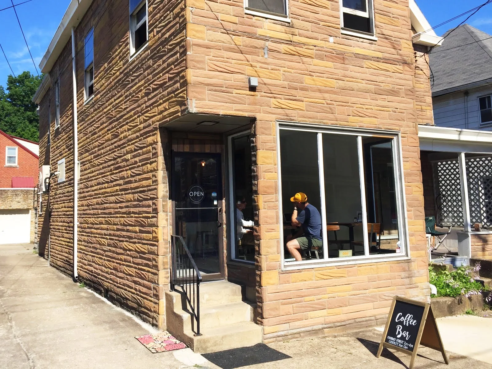 corner coffee shop in historic brick building with large storefront windows and open sign., quantum bean coffee, morgantown