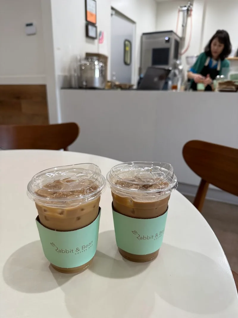 two iced coffee drinks with mint sleeves on white table in café., rabbit and bean coffee bar, la habra
