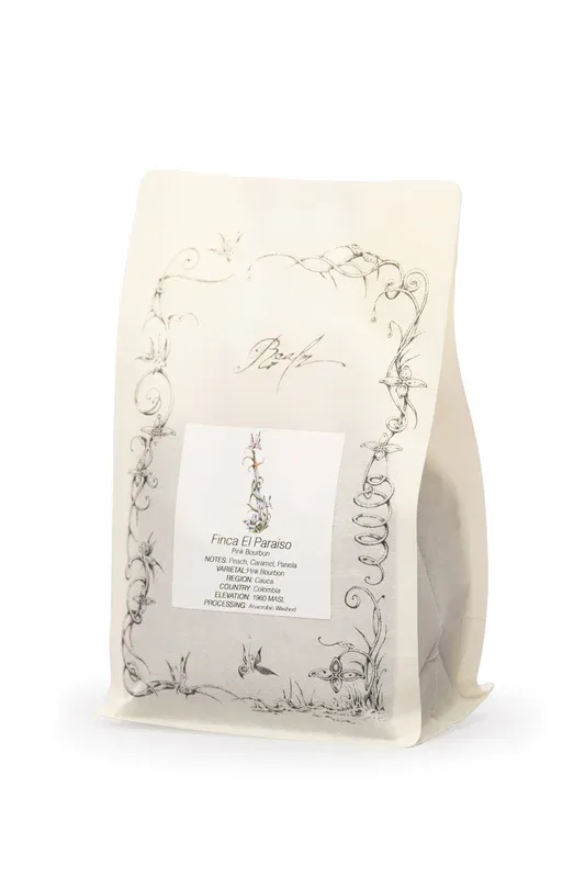 cream-colored coffee bag with botanical line drawings and product label visible., realm coffee co., new york city