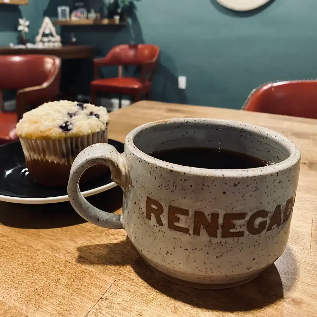 ceramic mug with coffee, muffin, and cozy cafe interior with teal walls., renegade coffee, kansas city
