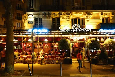 illuminated nighttime café storefront with elegant signage and outdoor seating area., restaurant bistrot le dôme paris 15, pa