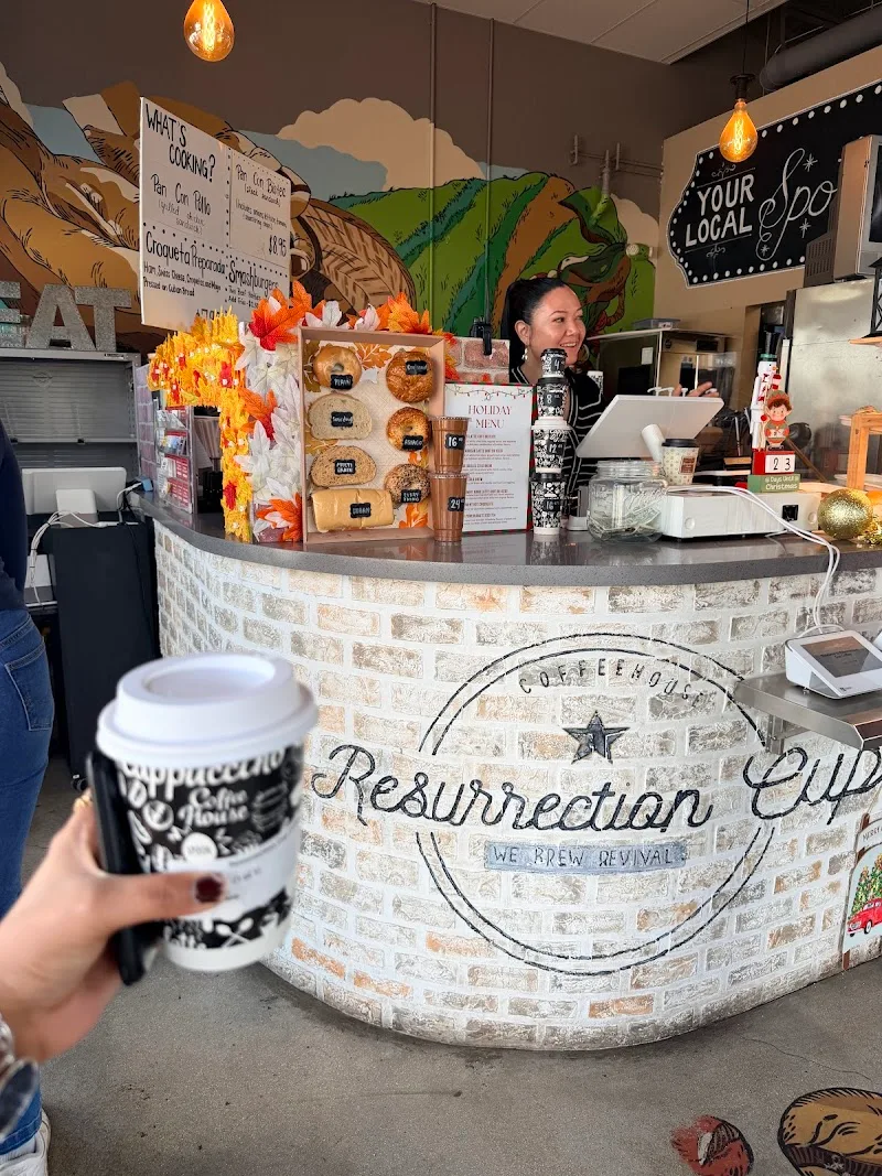 customer holding coffee at resurrection coffee house counter with pastries displayed., resurrection cup coffee, miami