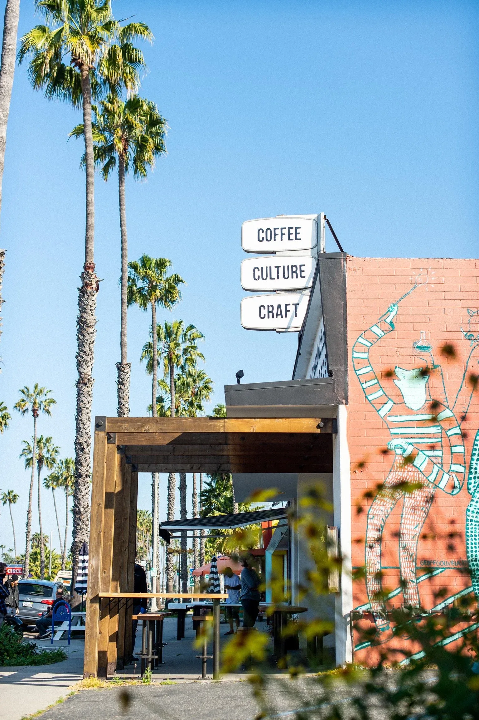 modern coffee shop storefront with "coffee culture craft" signage and tall palm trees., revolution roasters, san diego