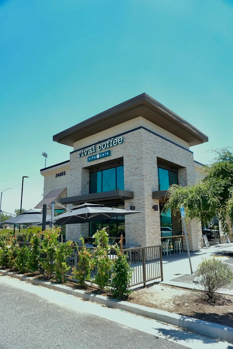 modern coffee shop building with brick facade and outdoor seating area under umbrellas., rival coffee co., murrieta