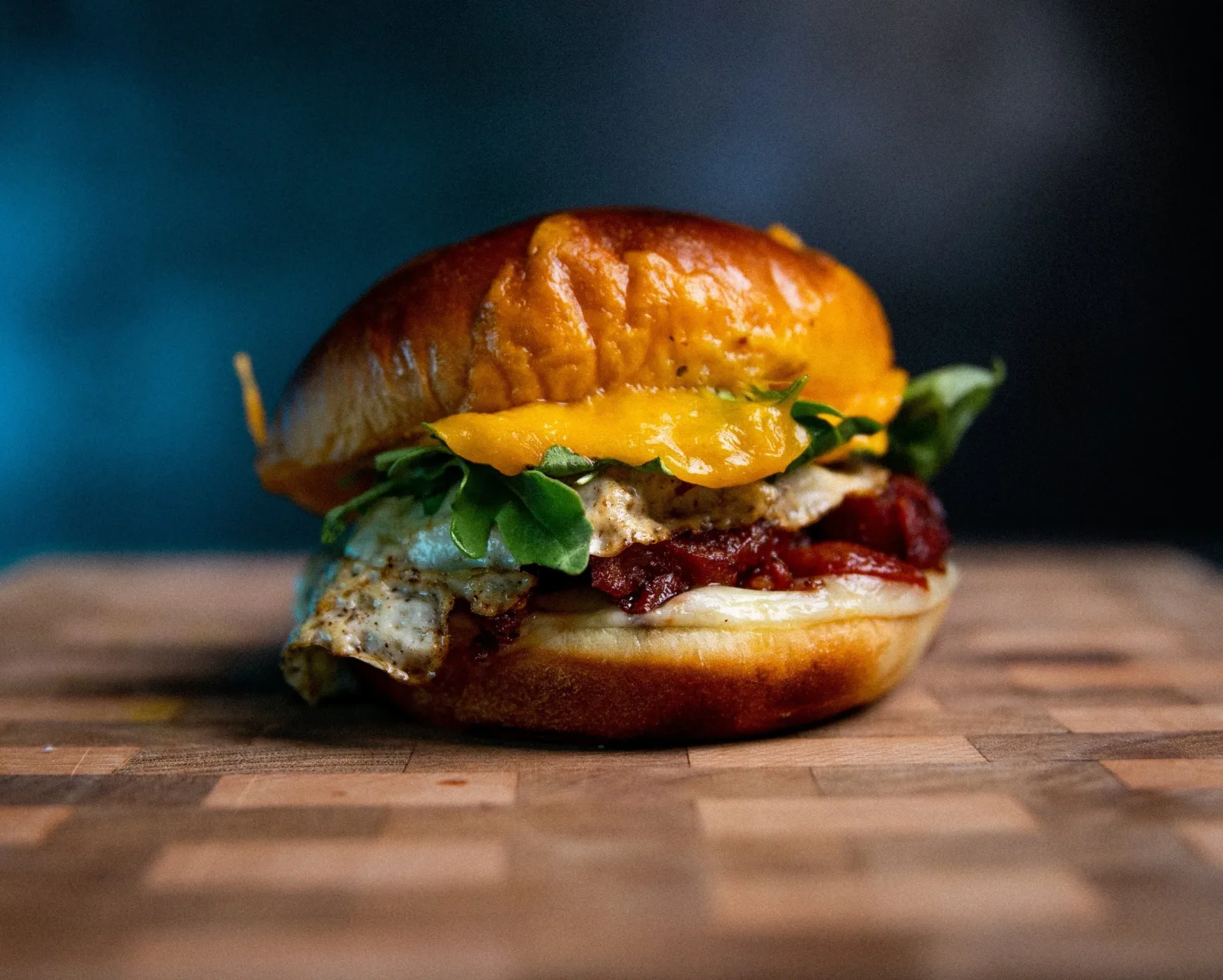 gourmet burger with golden bun, patty, red sauce, yellow cheese, and microgreens., rival coffee co., murrieta