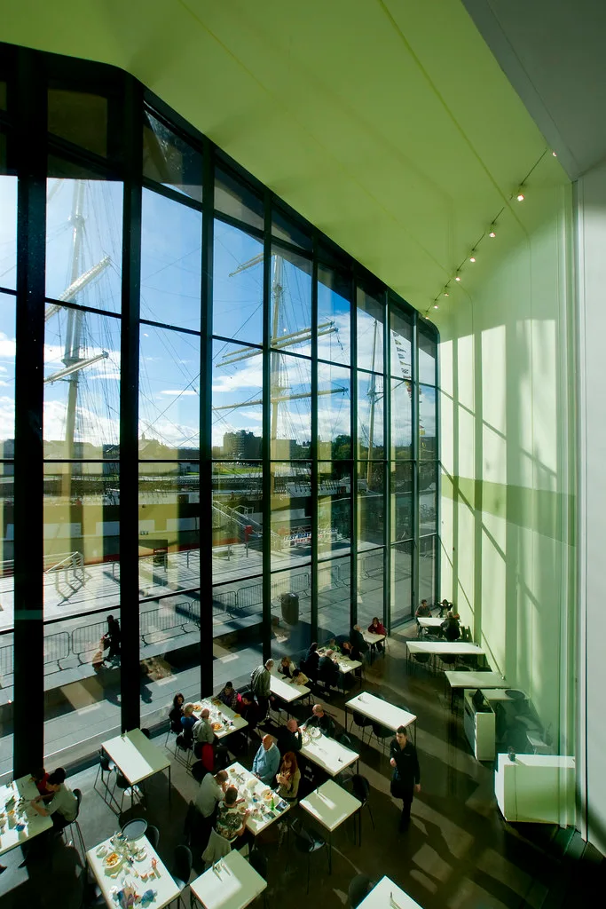 bright green cafeteria with tall windows overlooking historic sailing ship and water., riverside museum, glasgow