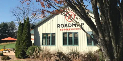 white building with "roadmap coffeeworks" sign, outdoor seating area visible., roadmap coffeeworks, lexington
