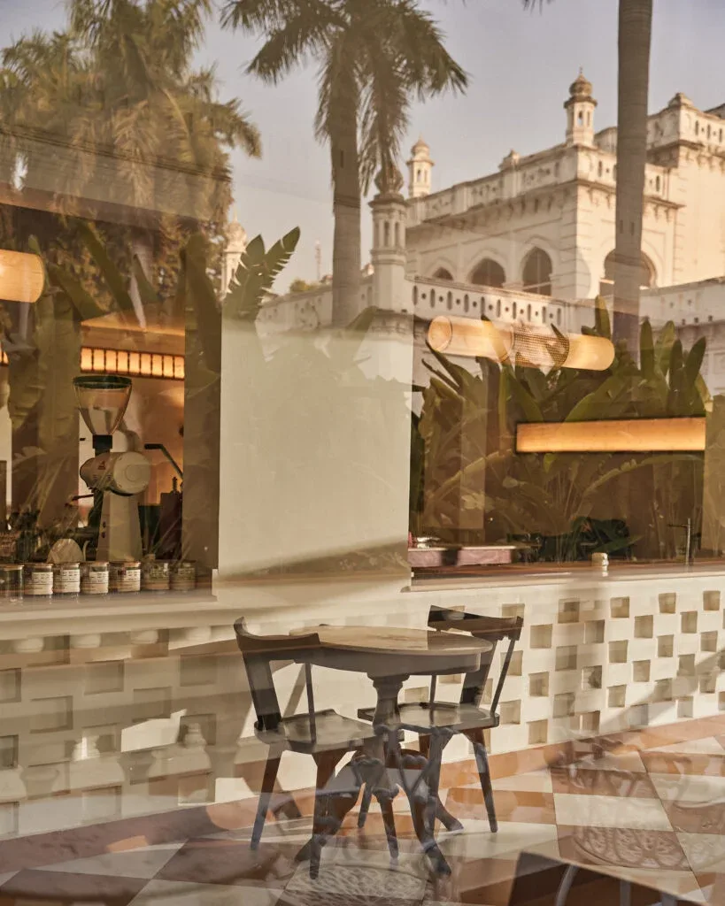 courtyard with table, chairs, palm trees, and mosque architecture backdrop., roastery coffee house | jahangirabad palace, luc
