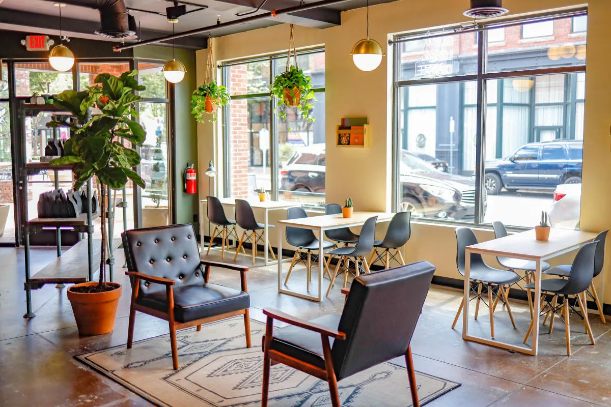 modern office lobby with yellow walls, hanging plants, wooden tables, and mid-century chairs., rock hill coffee, rock hill