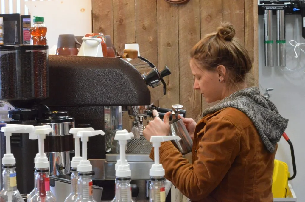 barista in brown jacket operating espresso machine at coffee counter., rocky mountain roastery cafe, granby