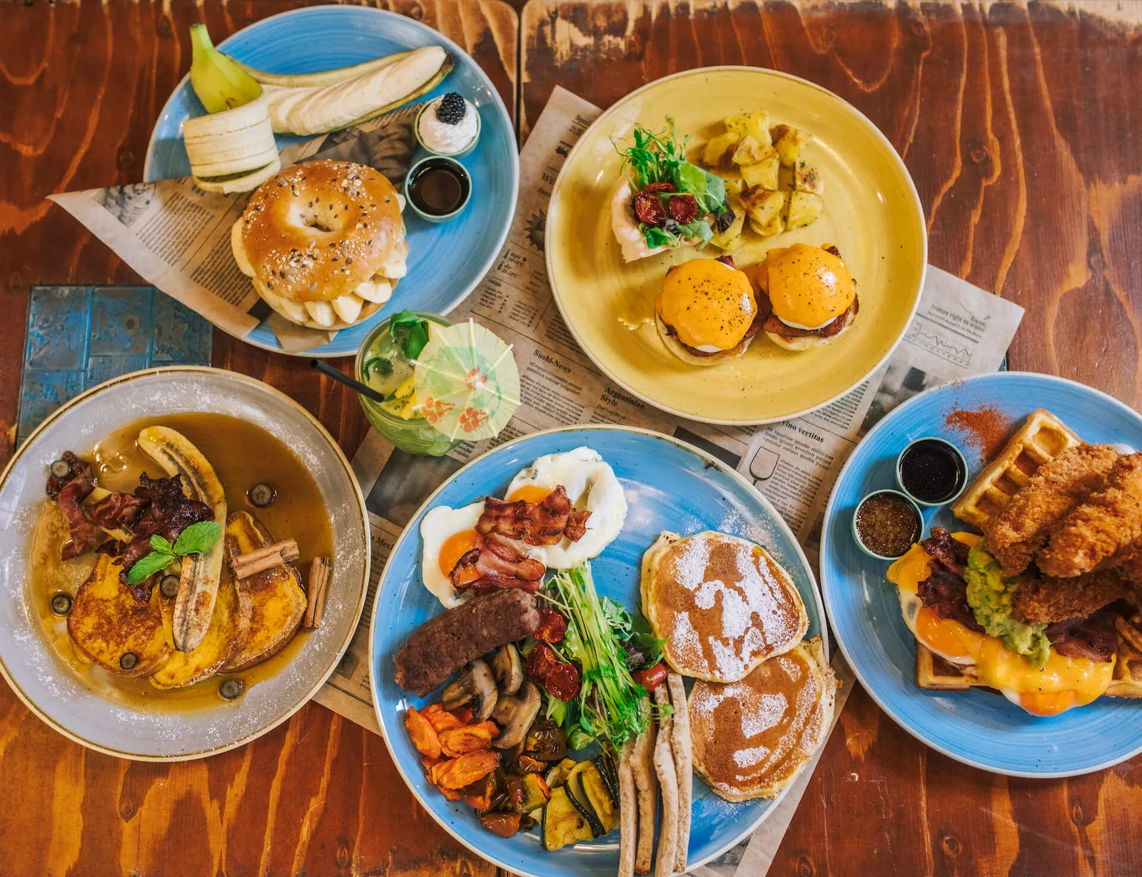 assorted breakfast plates with pancakes, waffles, eggs, and bacon on wooden table., rooster cafe firenze - sant'egidio, flore