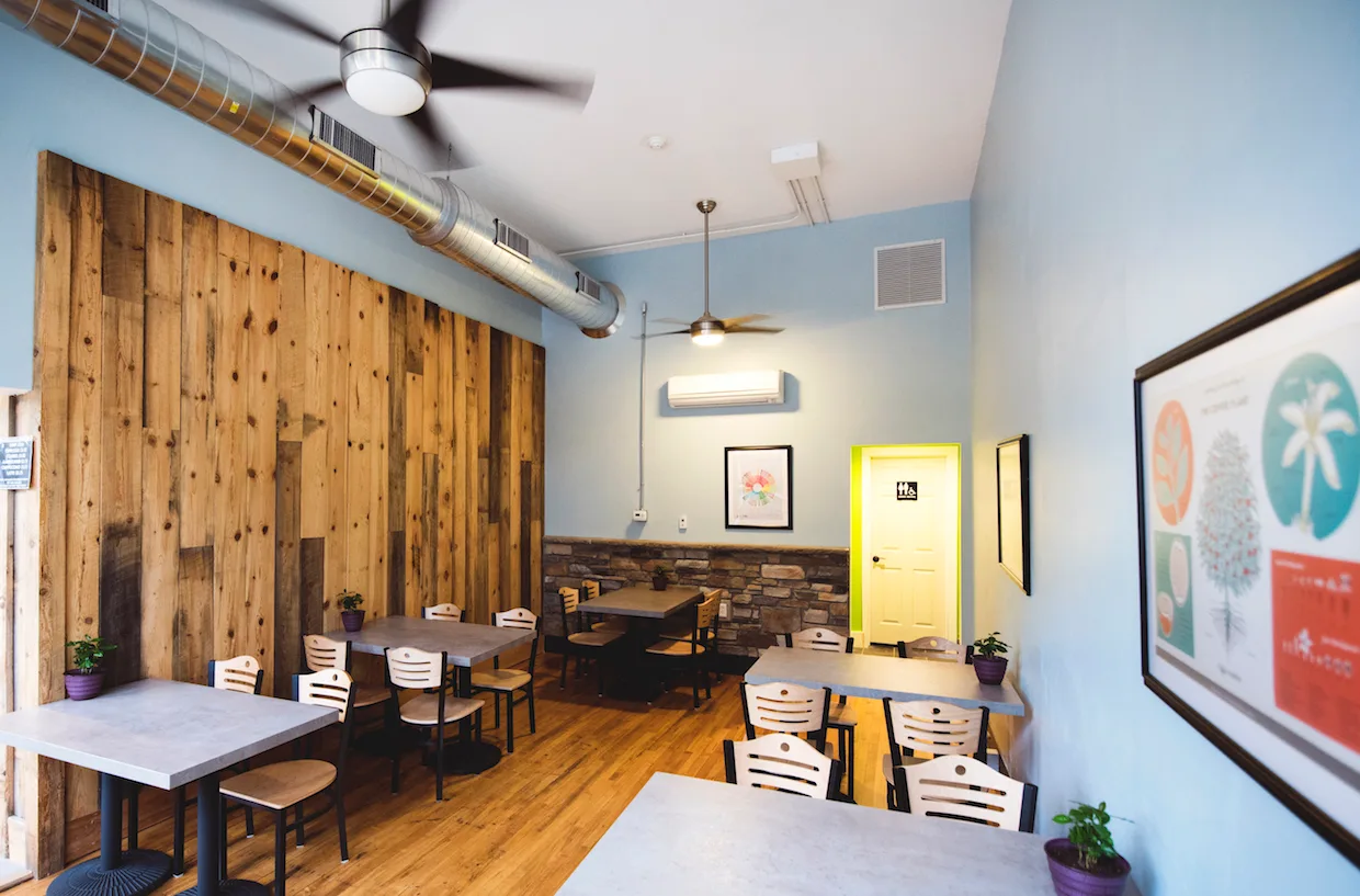 modern café interior with wooden accent wall, light blue walls, multiple dining tables., roots roasting, saint paul