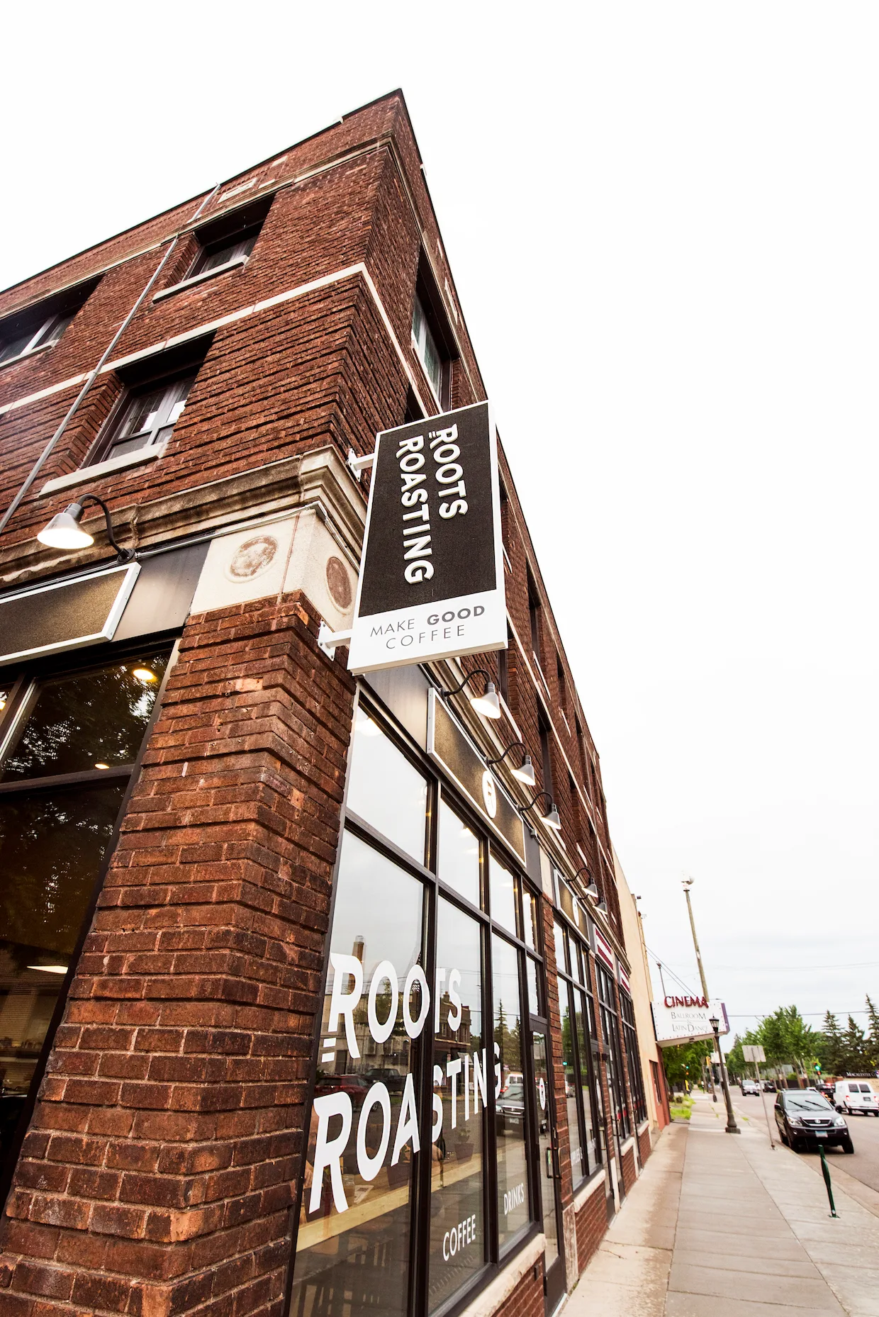 brick corner building with roots roasting coffee shop storefront and signage., roots roasting, saint paul