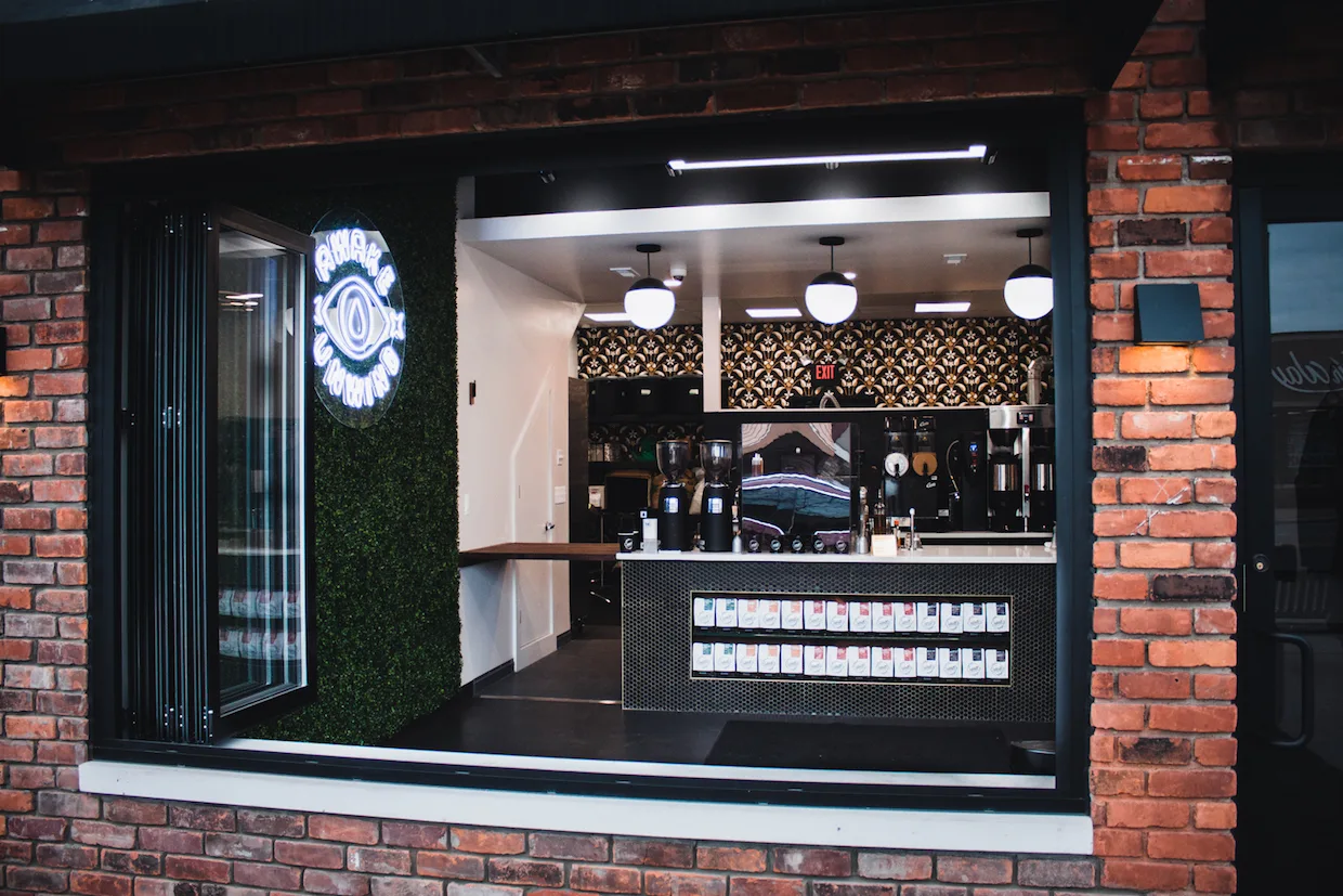 modern storefront with neon sign, plant wall, and cosmetics display counter., sabbath coffee, clawson