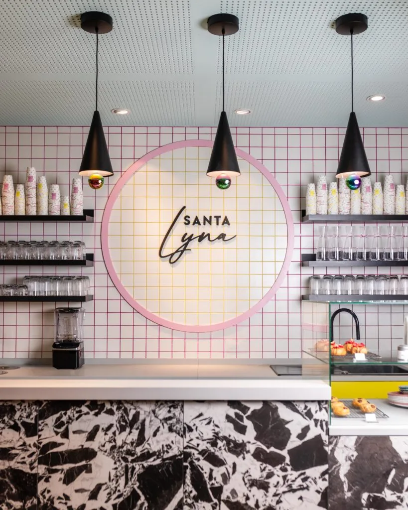 modern salon interior with pink neon sign and hanging pendant lights above counter., santa lyna, paris