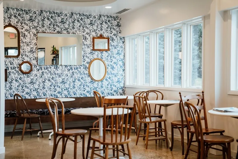 modern café interior with blue floral wallpaper, wooden chairs, and natural light., schuil coffee company, grand rapids