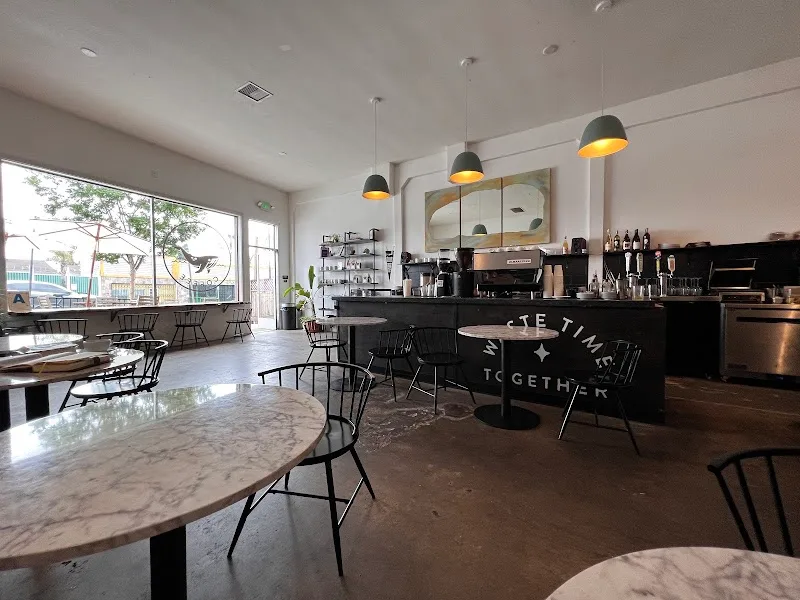 modern café interior with black counter, pendant lights, and marble tables., scrimshaw coffee, san diego