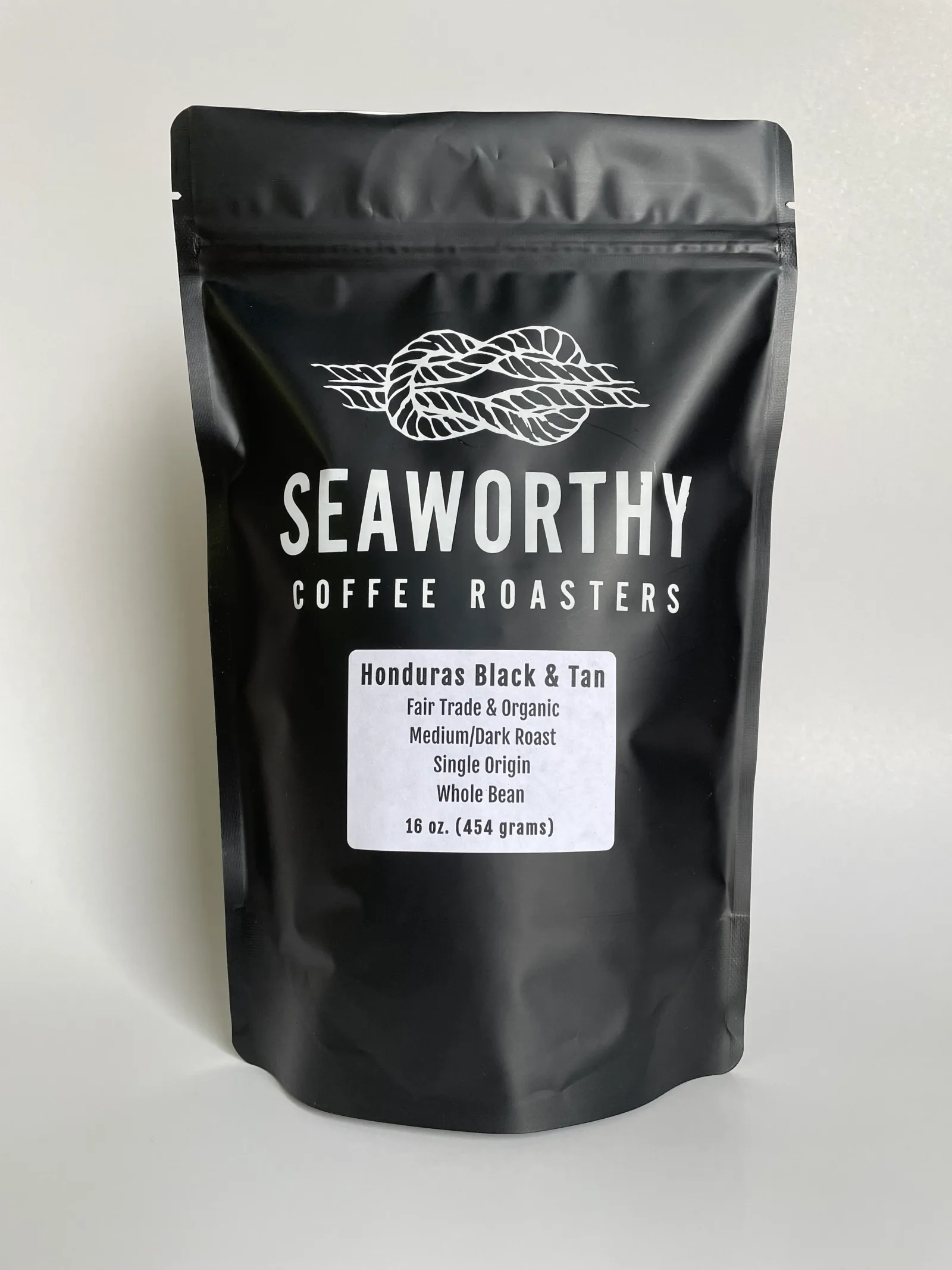 black coffee bag with rope logo and white label text on neutral background., seaworthy coffee roasters, south kingstown