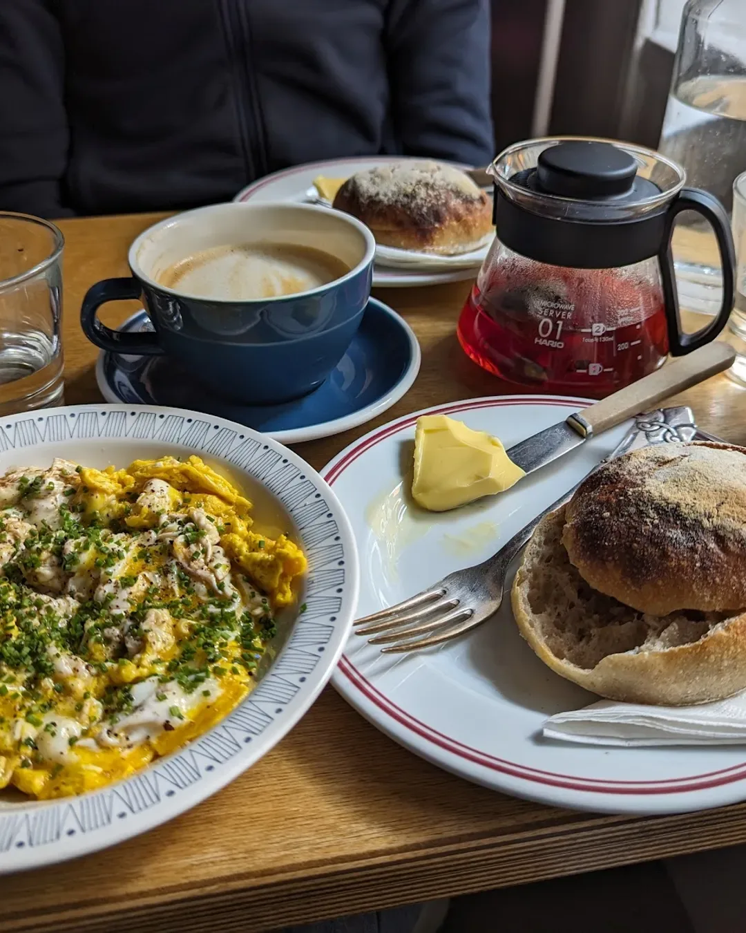breakfast table with hummus, bread, coffee, pastry, and fresh juice carafe., seks, copenhagen