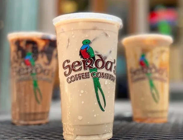 serosa coffee company beverages displayed with colorful parrot logo on cups., serda's coffee company, alabama