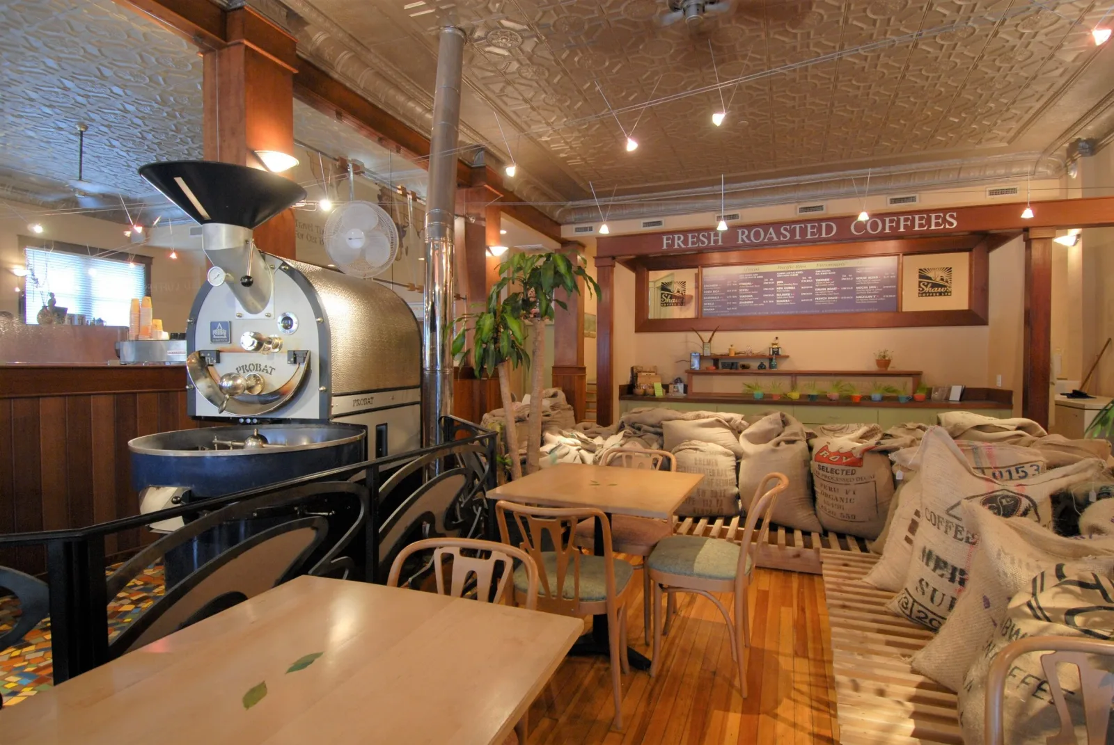 coffee roastery interior with roaster machine, seating, and burlap coffee bags displayed., shaw's coffee, st. louis