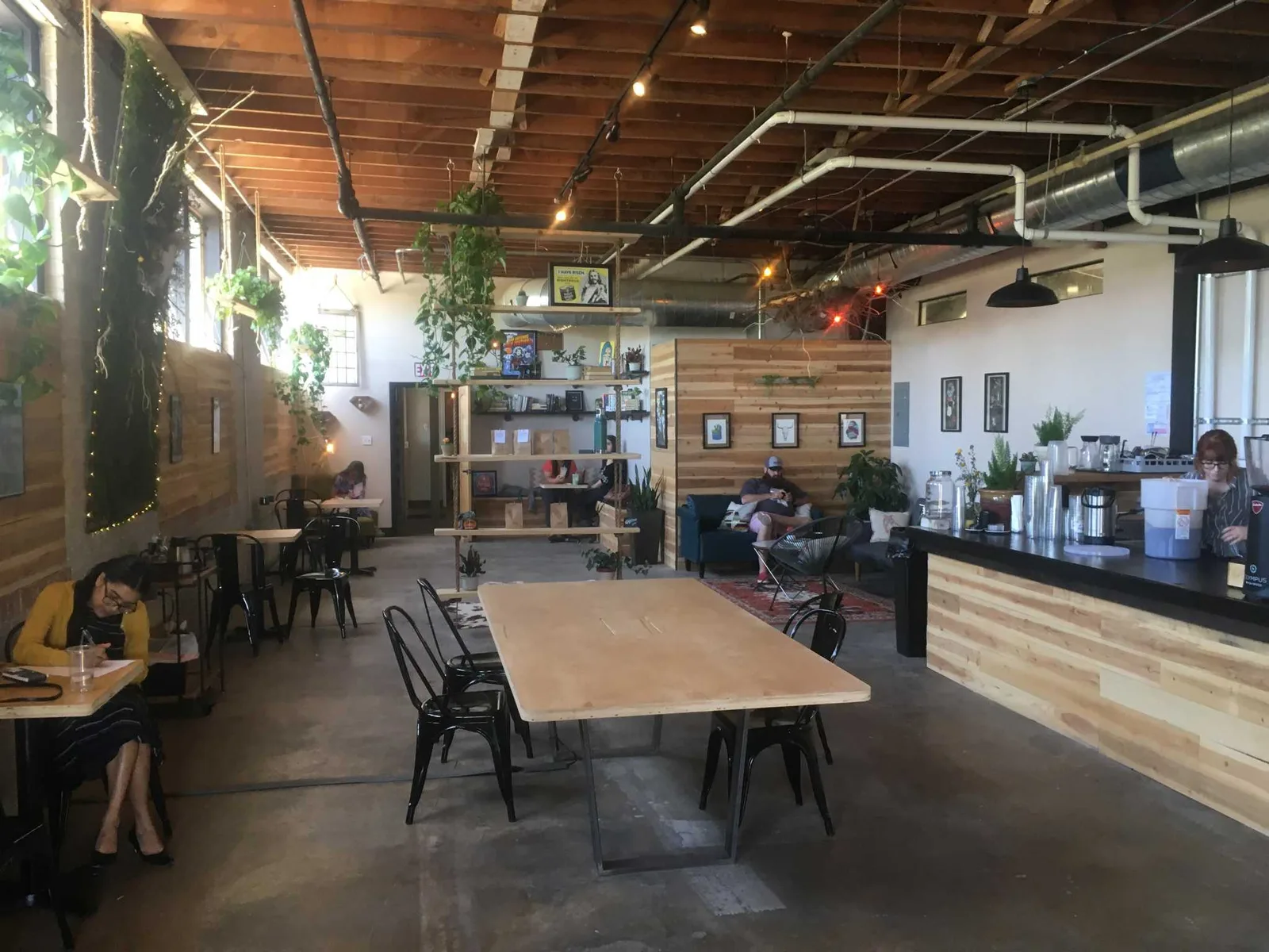 modern café interior with wooden accents, plants, and communal seating areas., shotgun house coffee roasters, san antonio