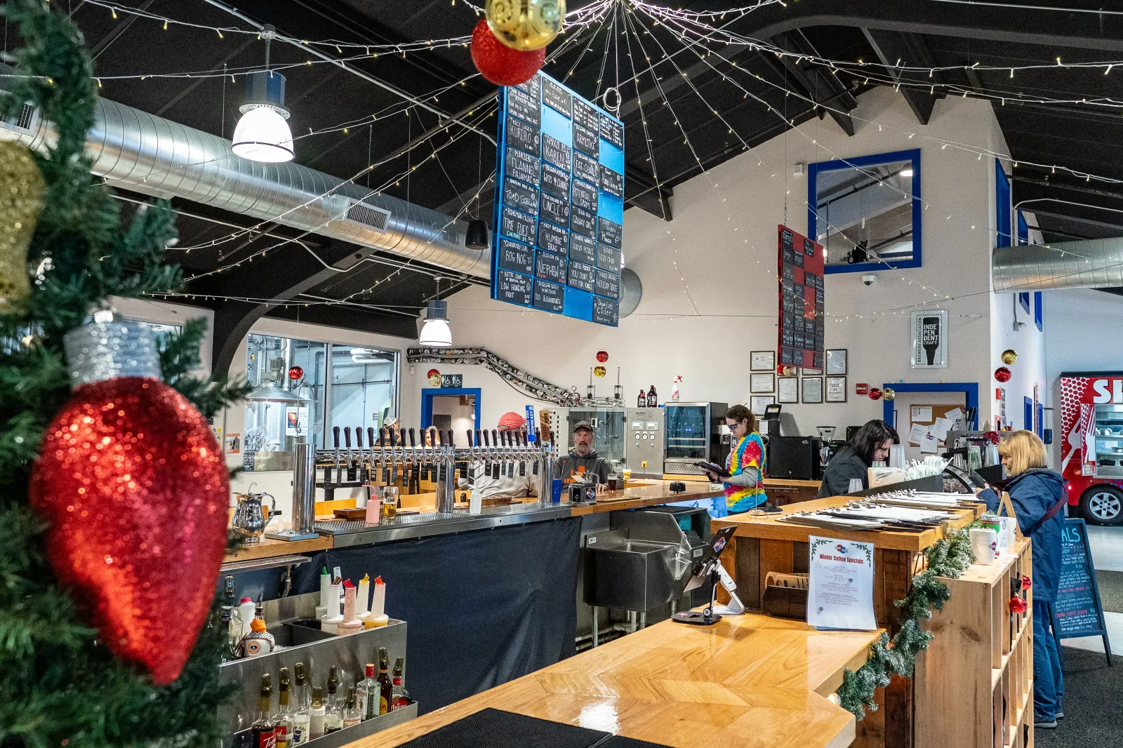 festive brewery or coffee shop interior decorated with red ornaments and greenery., side by each, auburn