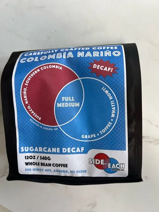 blue and black coffee bag labeled colombia narino decaf, 12oz whole beans., side by each, auburn